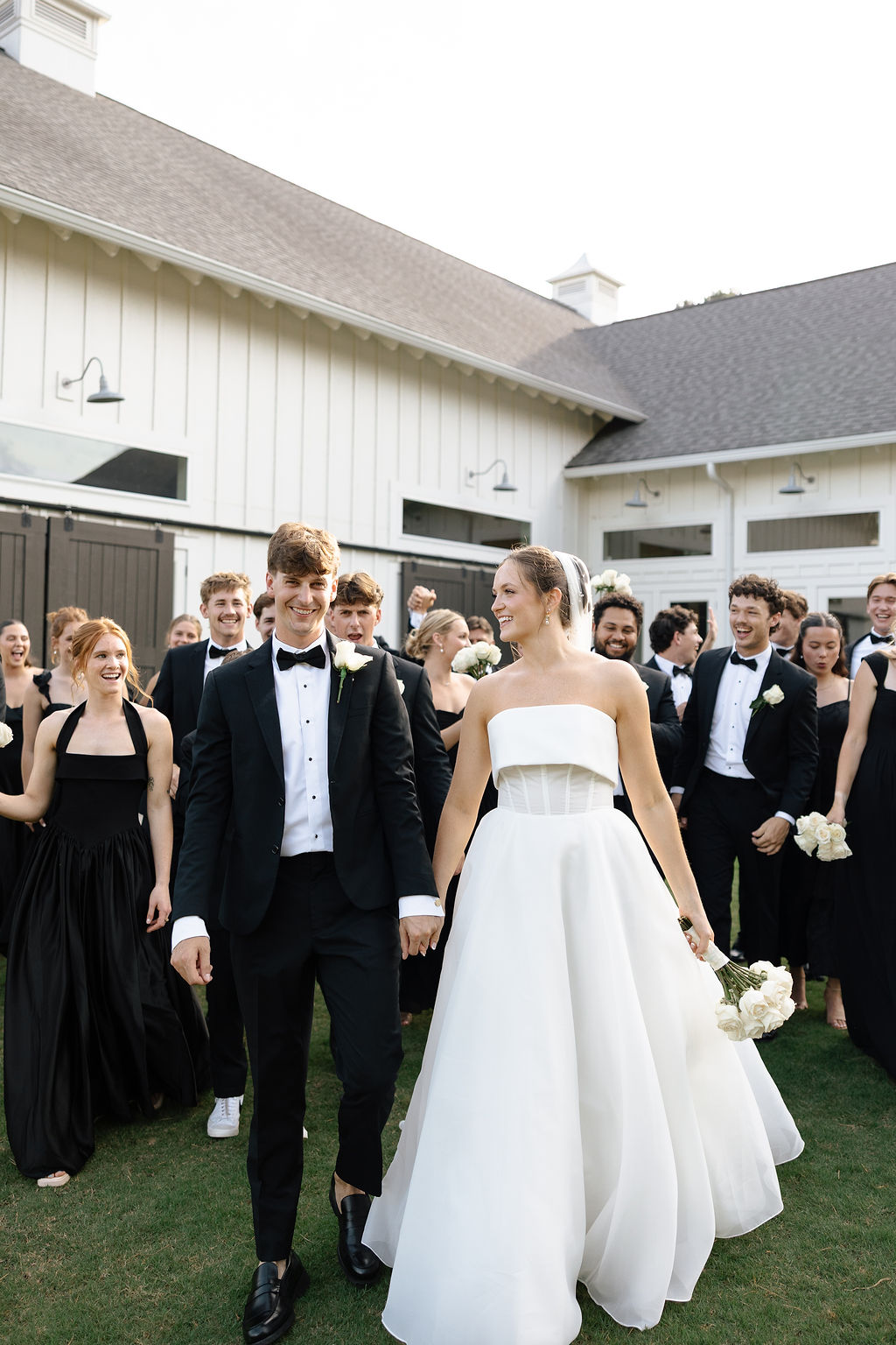 Couple walking on the Lawn of Daisy Hill Venue in Georgia with their bridal party